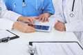 Group of doctors at medical meeting. Close up of physician using touch pad or tablet computer Royalty Free Stock Photo