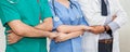 Group of doctors and nurses holding hands together in a medical team . Cooperation Royalty Free Stock Photo