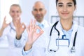 Group of doctors showing OK or approval sign with thumb up. High level and quality medical service, best treatment and Royalty Free Stock Photo