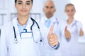 Group of doctors showing OK or approval sign with thumb up. High level and quality medical service, best treatment and Royalty Free Stock Photo