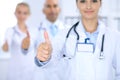 Group of doctors showing OK or approval sign with thumb up. High level and quality medical service, best treatment and Royalty Free Stock Photo