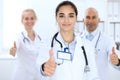 Group of doctors showing OK or approval sign with thumb up. High level and quality medical service, best treatment and Royalty Free Stock Photo