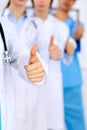 Group of doctors showing OK or approval sign with thumb up. High level and quality medical service, best treatment and Royalty Free Stock Photo