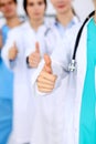 Group of doctors showing OK or approval sign with thumb up. High level and quality medical service, best treatment and Royalty Free Stock Photo