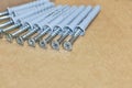 Group of dowels and nails on the bottom of cardboard box. Storage of materials for repair. Dowels for fixing to concrete. Royalty Free Stock Photo