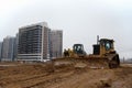 Group of dozers with buckets at construction site. Bulldozer during land clearing, grading, pool excavation, utility trenching and