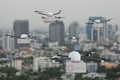 A group of drones transporting with a first aid box flying. With the city as a background