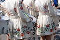 Group of drummer girls in white Ukrainian costumes with traditional red ornament