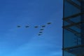 Group of eight russian military fighter jet planes flying in a v shape triangular formation high in blue sky during Vicotry Day