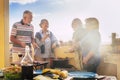 Group of elderly people have fun in frienship outdoor cooking a bbq all together. Senior couples friends enjoy leisure time eating Royalty Free Stock Photo