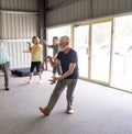 Group of elderly senior people practicing Tai chi class in age care gym facilities Royalty Free Stock Photo