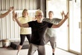 Group of elderly senior people practicing Tai chi class in age care gym facilities