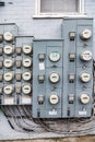 group of electric meters of an apartment building hang on a brick wall. Close-up