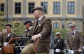 Group of elegant cycling people wearing old fashioned tweed clothes