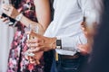 Group of elegant people holding glasses of champagne at luxury w