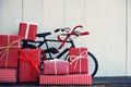 Group of elegant red gift box stack decorated with vintage toy bicycle on wood background, vibrant valentine lovely present Royalty Free Stock Photo
