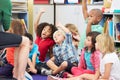 Group of Elementary Pupils In Classroom Answering Question Royalty Free Stock Photo