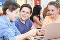 Group Of Elementary School Children Working Together In Computer