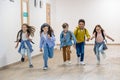 Group of elementary school kids running in school corridor. Royalty Free Stock Photo