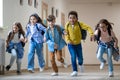 Group of elementary school kids running in school corridor. Royalty Free Stock Photo