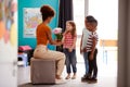 Group Of Elementary School Pupils Giving Female Teacher Thank You Gift Of Flowers Royalty Free Stock Photo