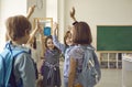 Group of elementary school students stand together raising their hands feeling the spirit of unity. Royalty Free Stock Photo