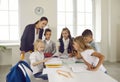 Group of elementary school students with teacher drawing pictures in the classroom Royalty Free Stock Photo