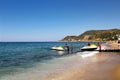 A group of employees of the water sports center descends the jet ski onto the water using a special device