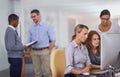 Group of employees at work talking, collaborating, and brainstorming on a computer. Diverse team working together on a Royalty Free Stock Photo