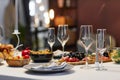 Group of empty flutes, plate with napkin and wooden bowl with pickled tomatoes