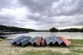 group of empty kayaks on the shore of the lake with dramatic clouds Royalty Free Stock Photo