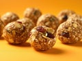 Group of energy balls with nuts and cranberries on an orange background