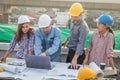 Group of engineer checking the blueprint with laptop and talking about construction project with commitment to success at Royalty Free Stock Photo