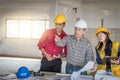 Group of engineer checking the blueprint on the table and talking about construction project with commitment to success at Royalty Free Stock Photo