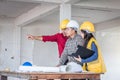 Group of engineer checking the blueprint on the table and talking about construction project with commitment to success at Royalty Free Stock Photo