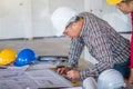 Group of engineer checking the blueprint on the table and talking about construction project with commitment to success at Royalty Free Stock Photo