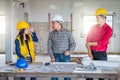 Group of engineer checking the blueprint on the table and talking about construction project with commitment to success at Royalty Free Stock Photo