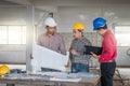 Group of engineer checking the blueprint on the table and talking about construction project with commitment to success at Royalty Free Stock Photo