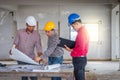 Group of engineer checking the blueprint on the table and talking about construction project with commitment to success at Royalty Free Stock Photo