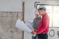 Group of engineer checking the blueprint on the table and talking about construction project with commitment to success at Royalty Free Stock Photo