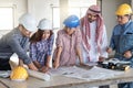 Group of engineer checking the blueprint on the table and talking about construction project with commitment to success at Royalty Free Stock Photo