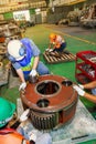 A group of engineer are repair the large engine gear wheels