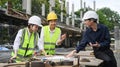 Group of engineer supervisor wearing safety helmet working, checking plan together at construction site Royalty Free Stock Photo