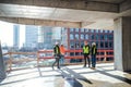 Group of engineers standing on construction site, talking.