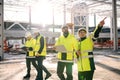 Group of engineers standing outdoors on construction site, working.