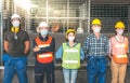 A group of engineers, technicians Asian and Caucasian, Standing at the door of an industrial factory