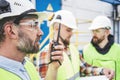 Group of engineers using walkie-talkie talking on produce site