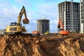 Group of the excavators for dig ground trenching at a construction site for foundation and installing storm pipes. Backhoe digging Royalty Free Stock Photo