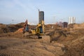 Group of the excavators for dig ground trenching at a construction site for foundation and installing storm pipes. Backhoe digging Royalty Free Stock Photo