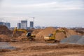 Group of the excavators for dig ground trenching at a construction site for foundation and installing storm pipes. Backhoe digging Royalty Free Stock Photo